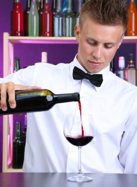 Barmen kırmızı şarap cam içine yağıyor