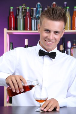 Barmen konyak cam içine yağıyor