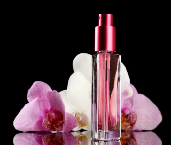 Vrouw perfume in mooie fles en orchideebloemen, op zwarte achtergrond — Stockfoto