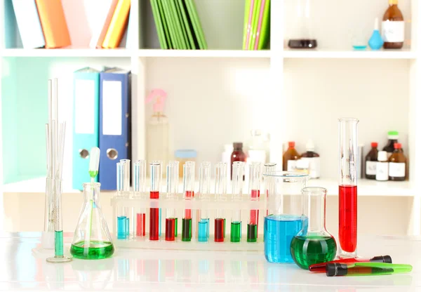 Different laboratory glassware with color liquid on laboratory background — Stock Photo, Image