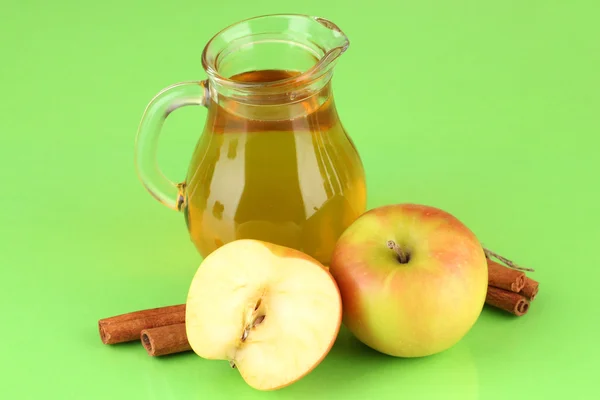 Caraffa piena di succo di mela e mela su sfondo a colori — Foto Stock