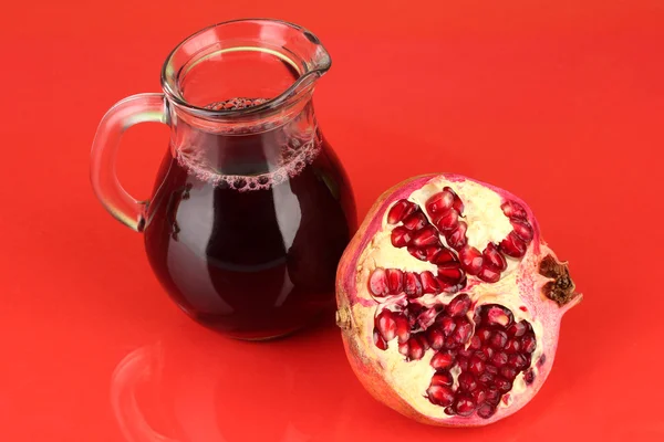 Jarro cheio de suco de romã, em fundo de cor — Fotografia de Stock