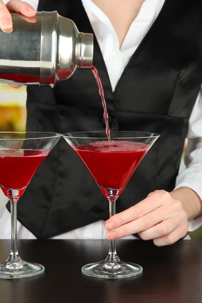 Barmani ruku s nalitím koktejl šejkru do sklenic, na světlé pozadí — Stock fotografie