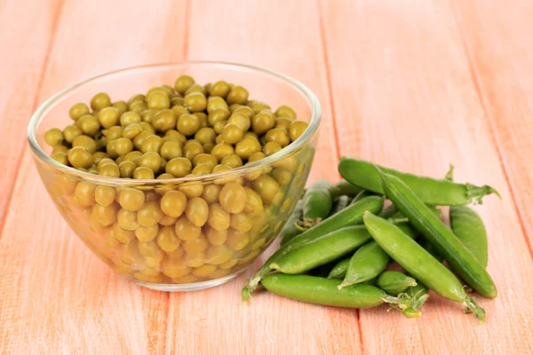 Guisantes verdes sobre fondo de madera — Foto de Stock