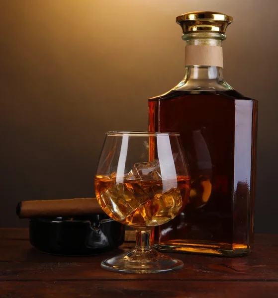 Brandy avec glace sur table en bois sur fond marron — Photo