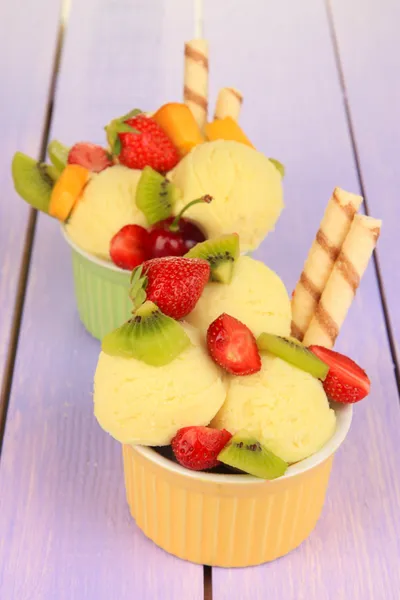 Delicioso sorvete com frutas e bagas em tigela na mesa de madeira — Fotografia de Stock