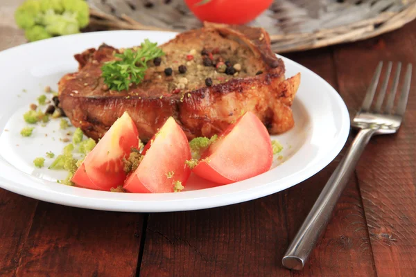 Trozo de carne frita en el plato en la mesa de madera de cerca — Foto de Stock