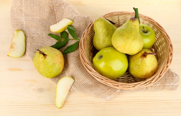 Päron i korg på säckväv på träbord — Stockfoto