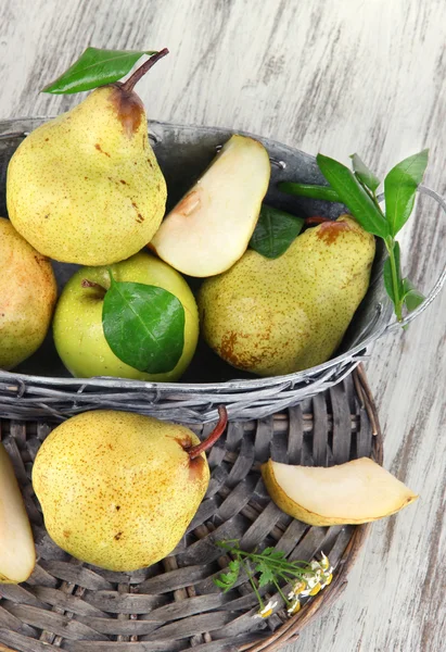 Pears in basket on braided tray on wooden table — Stock Photo, Image