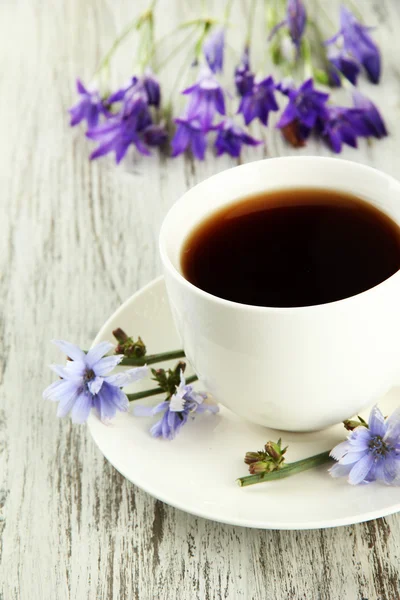 Cup of tea with chicory, on wooden background — Stock Photo, Image