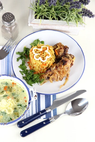 Суп и рис с мясом в тарелках на салфетке на столе — стоковое фото