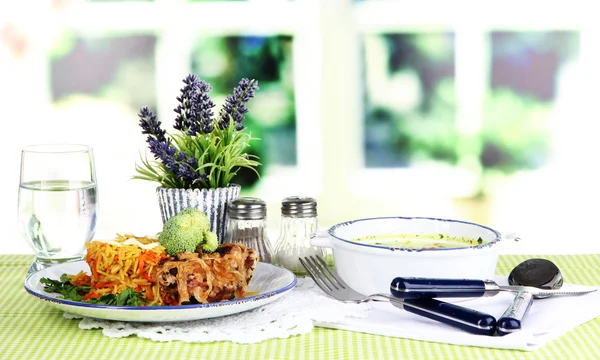 Suppe und Reis mit Fleisch in Tellern auf Serviette auf Tischdecke auf Zimmerhintergrund — Stockfoto