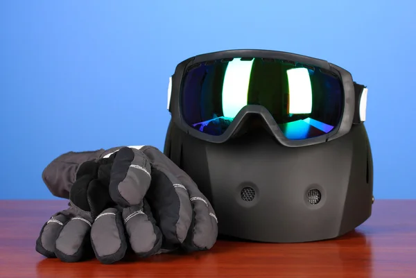 Kış spor gözlük, kask ve eldivenler, mavi zemin üzerine — Stok fotoğraf