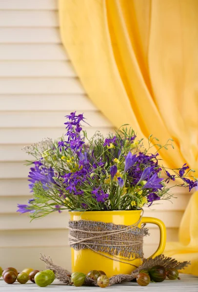 Güzel Kupası ve ahşap masa üzerinde meyveleri kır çiçekleri buketi — Stok fotoğraf