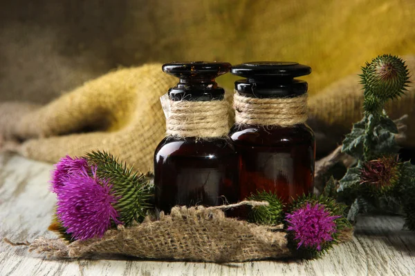 Medicine bottles with thistle flowers — Stock Photo, Image