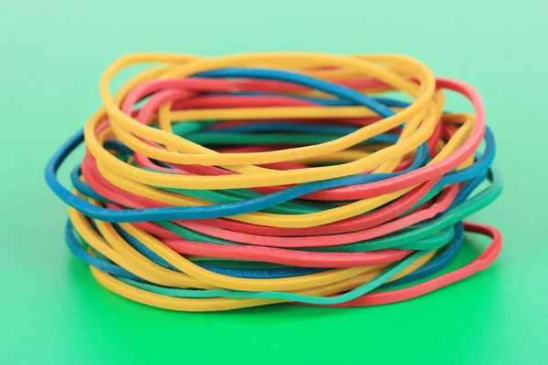 Colorful rubber bands on green background — Stock Photo, Image