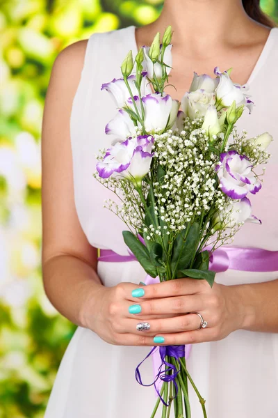 Žena drží kytici, na modrém pozadí, na světlé pozadí, detail — Stock fotografie