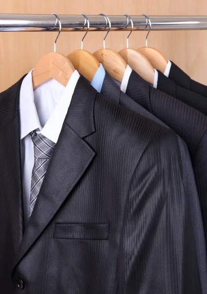 Pakken met shirts op hangers op houten achtergrond — Stockfoto