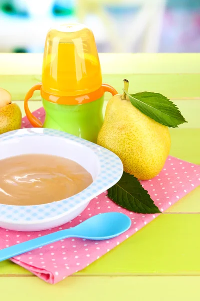 Tasty baby fruit puree and baby bottle on wooden table — Stock Photo, Image