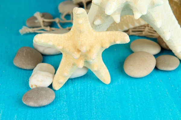 White starfishes on blue wooden table close-up — Stock Photo, Image