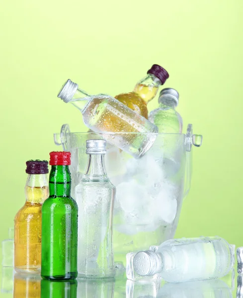 Minibar botellas en cubo con hielo, sobre fondo de color — Foto de Stock