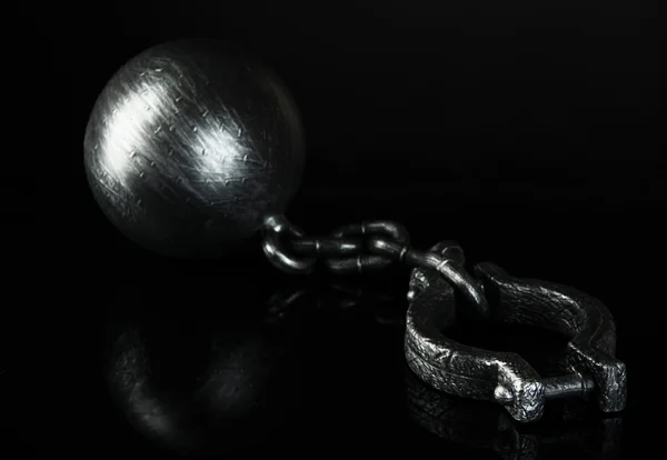 Шар и цепь на черном фоне — стоковое фото