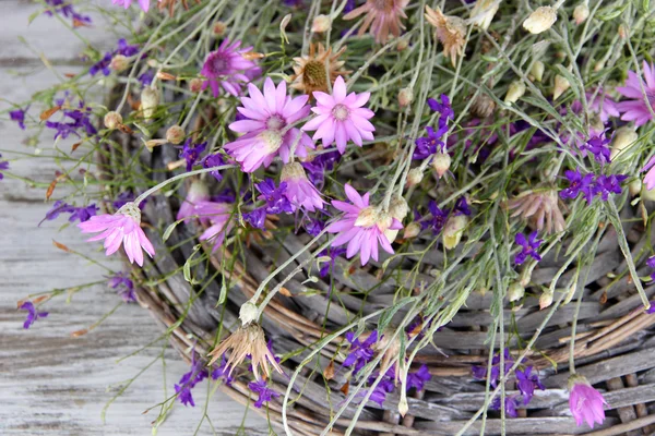 Vilda blommor, på wicker matta, på färg trä bakgrund野生の花、籐マット、木製の背景の色 — Stockfoto