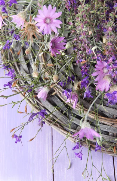 Flores silvestres, sobre estera de mimbre, sobre fondo de madera de color —  Fotos de Stock