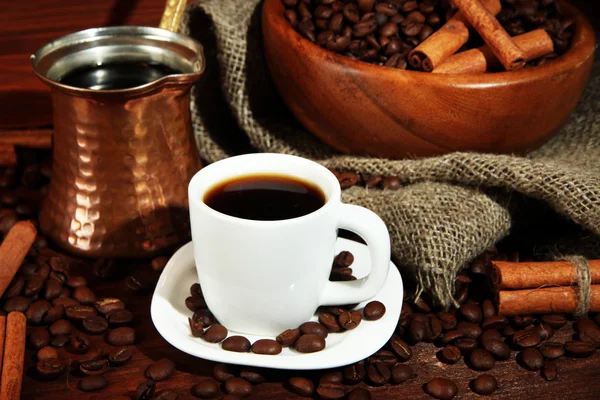 Xícara de café e metal turk no fundo de madeira — Fotografia de Stock