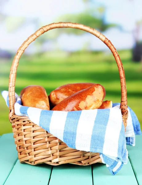 Fresh baked pasties in wicker basket, on bright background — Stock Photo, Image