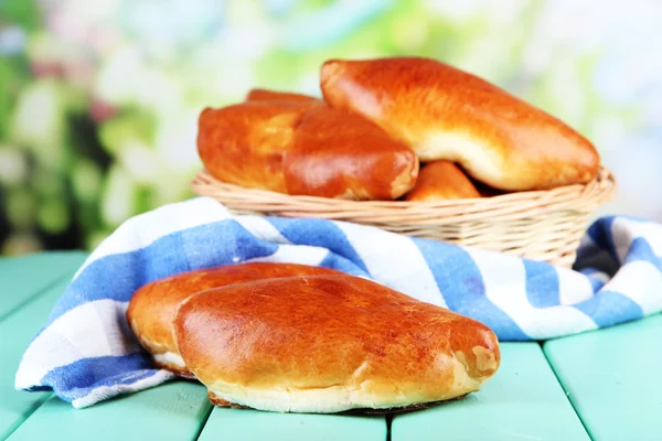 Frisch gebackenes Gebäck im Weidenkorb, auf hellem Hintergrund — Stockfoto