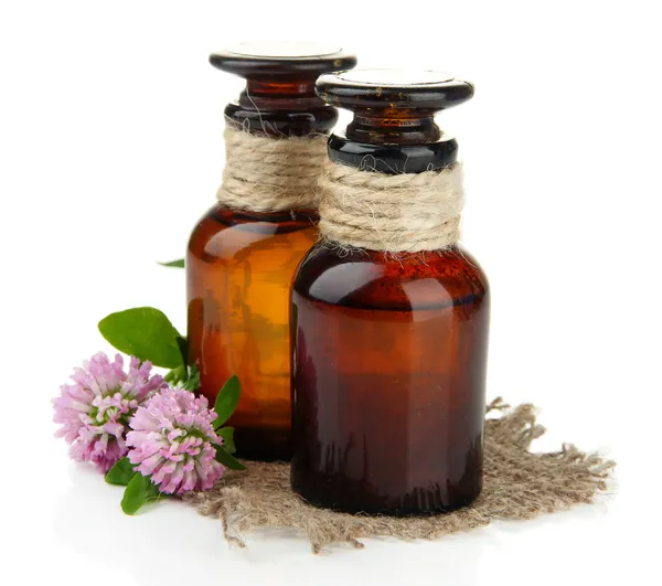 Medicine bottles with clover flowers, isolated on white — Stock Photo, Image