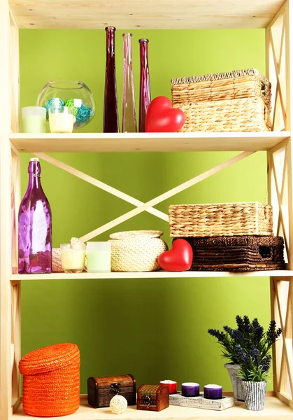 Hermosos estantes blancos con diferentes objetos relacionados con el hogar, en el fondo de la pared de color —  Fotos de Stock