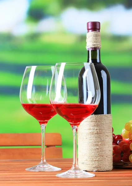 Weingläser auf Holztisch auf Naturhintergrund — Stockfoto