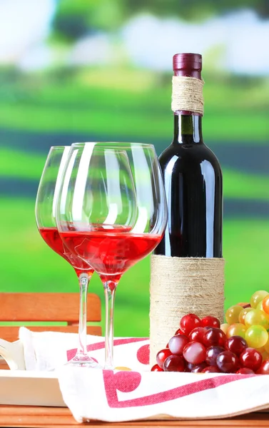 Doğa zemin üzerine ahşap masa tepsiye peçeteye şarap gözlük — Stok fotoğraf