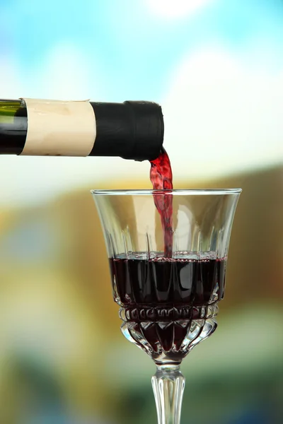 Rødvin som helles i vinglass, i lys bakgrunn – stockfoto