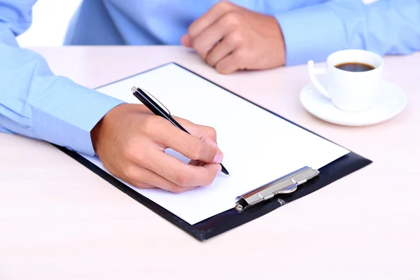 Empresário escrevendo no documento em close-up escritório — Fotografia de Stock