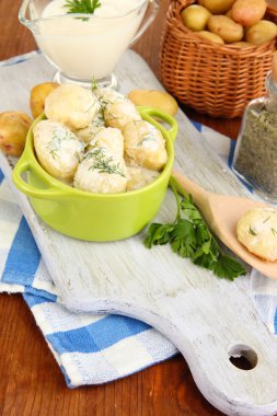 ekşi krema ve ahşap tahta masa yakın çekim üzerinde tava otlar ile ihale genç patates