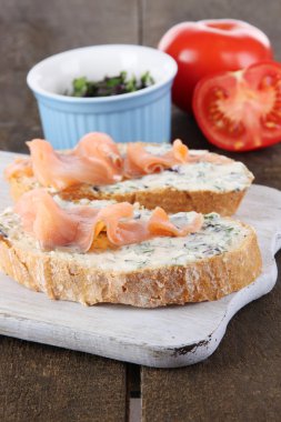 ahşap masa üzerinde kesme tahtası üzerinde balık sandviç