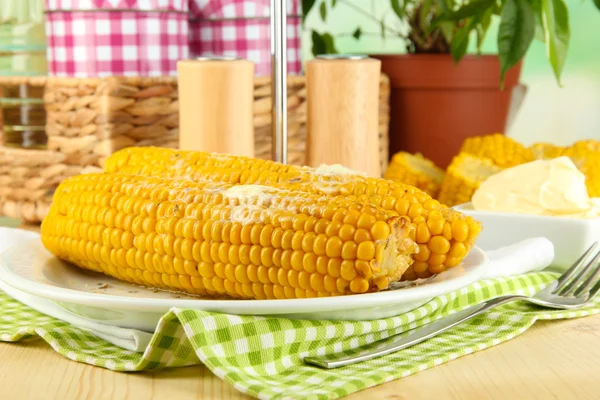 Aromatisierter gekochter Mais auf Teller auf Holztisch vor natürlichem Hintergrund — Stockfoto