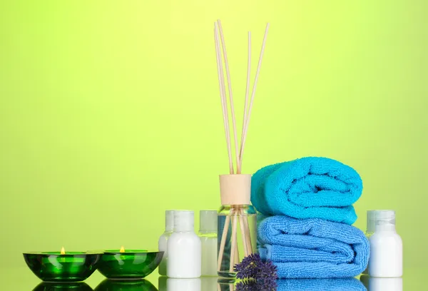 Bottle of air freshener, lavander and towels on green background — Stock Photo, Image