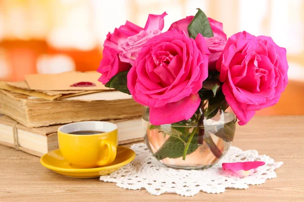 部屋の背景に木製のテーブルの上の花瓶に美しいピンクのバラ — ストック写真
