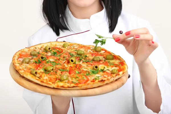 Mooi meisje chef-fornuis met pizza geïsoleerd op wit — Stockfoto