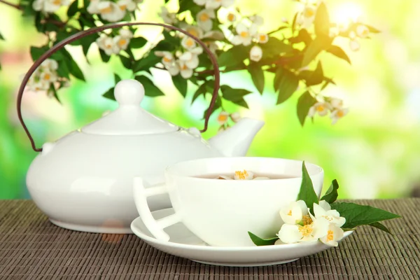 Šálek čaje s Jasmínou, na bambusové rohoži na světlé pozadí — Stock fotografie