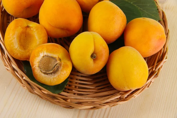 Apricots on wicker coasters on wooden table — Stock Photo, Image