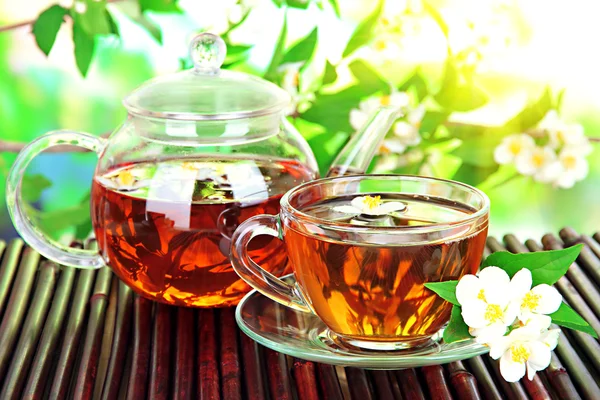 Taza de té con jazmín, sobre estera de bambú, primer plano —  Fotos de Stock