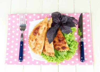 renkli ahşap zemin üzerinde plaka üzerinde taze otlar ile lezzetli chebureks