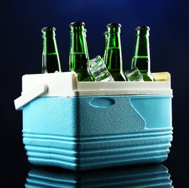 mini buzdolabı, koyu mavi zemin üzerine buz küpleri ile bira şişesi