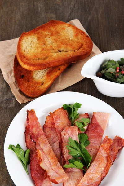 Bacon sur assiettes sur table en bois — Photo