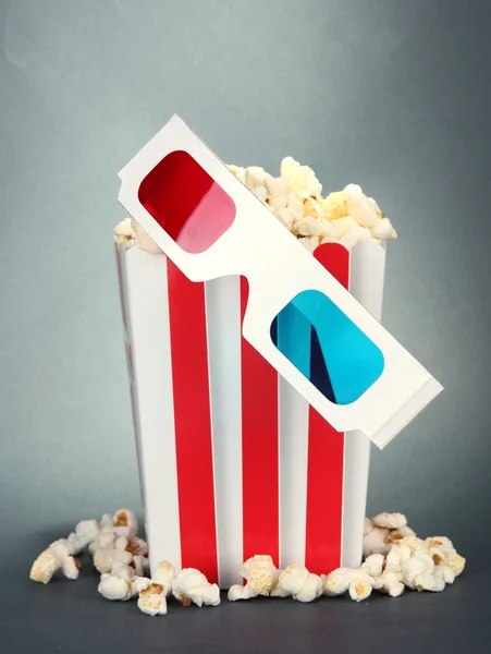 Popcorn a 3d brýle na šedém pozadí — Stock fotografie